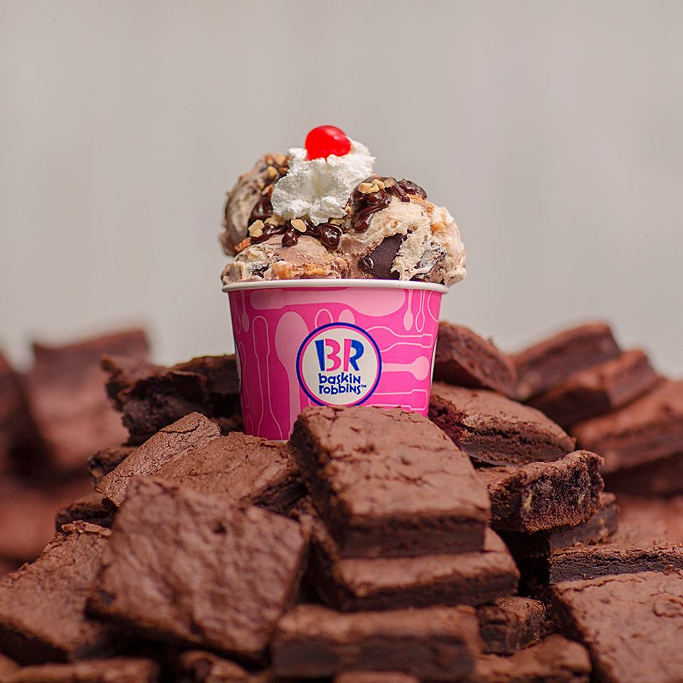 image of a pile of brownies with an ice cream sundae on top.