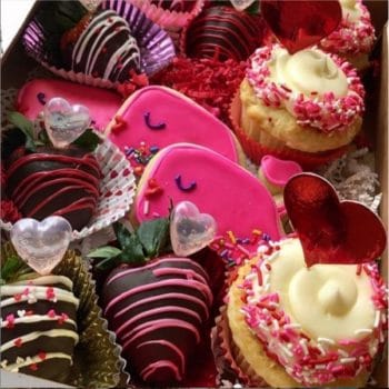 Image of heart shaped and smiling whale cookies and chocolate covered strawberries