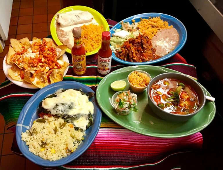 table of f different Mexican dishes on vibrantly colored plates