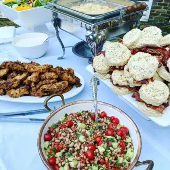 Salad, chicken, biscuits with bacon, and what appears to be a hashbrown casserole..