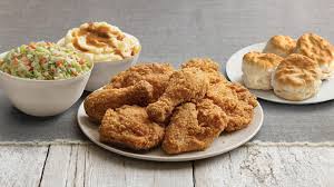 platter full of fried chicken, family size bowls of mashed potatoes and coleslaw, plate of biscuits