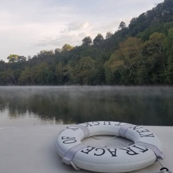 view from the boat, of fog on the river with the life preserver in foreground