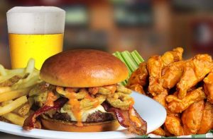 burger with bacon, wings, and a cold foaming beer